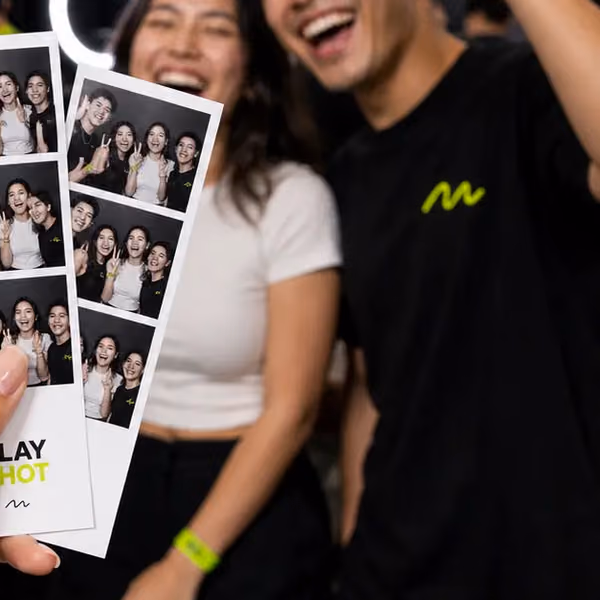 Friends grinning behind their PlayShot photo strip
