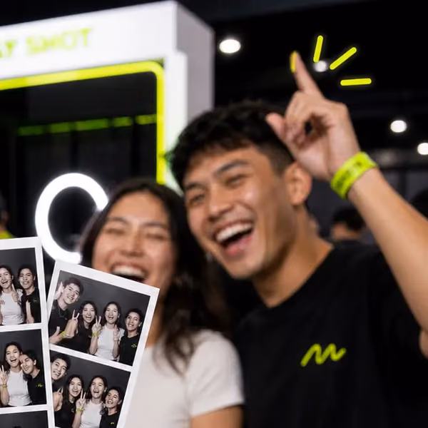 A friend pointing up and laughing in front of the print booth